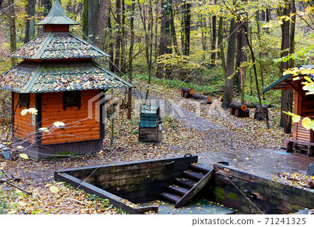 Old wooden forest font with spring water in the autumn forest. 71241325