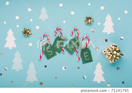 Christmas or winter New Year card template. Xmas gold gifts, paper tree and candy canes on pastel blue background. Christmas or winter New Year card template. Xmas gold gifts, paper tree and candy canes on pastel blue background. 71241795