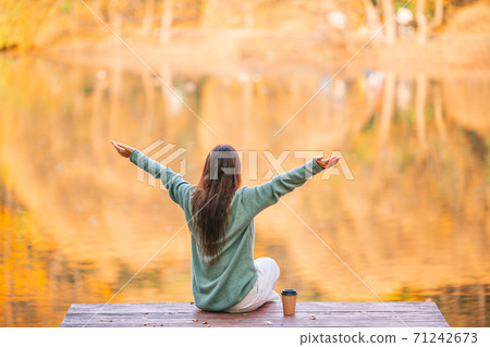 Fall concept - beautiful woman with coffee in autumn park Fall concept - beautiful woman with coffee in autumn park 71242673