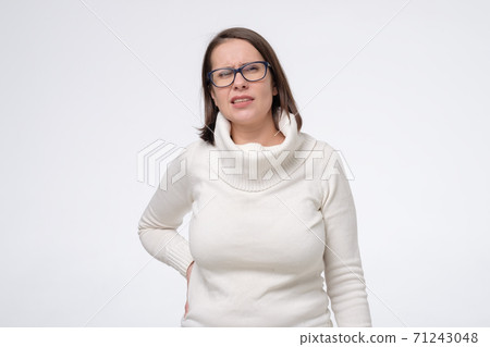 Loin spasm. Mature woman in glasses with hurt backbone. Loin spasm. Mature woman in glasses with hurt backbone. 71243048