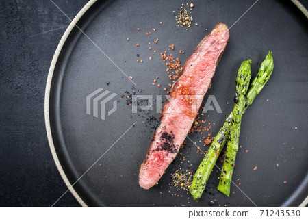 Modern design barbecue dry aged wagyu flank steak sliced with green asparagus  71243530