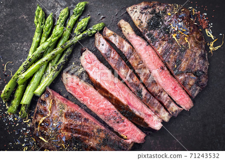 Barbecue dry aged wagyu flank steak sliced with green asparagus 71243532