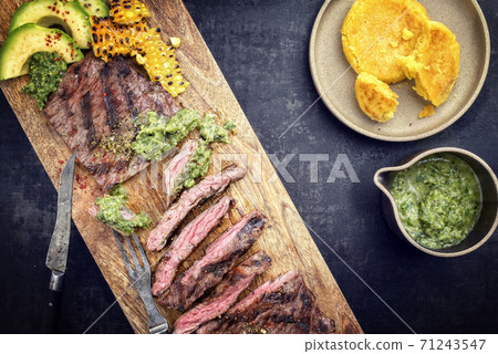 Barbecue dry aged wagyu flank steak with corn, avocado and chimichurri sauce  71243547