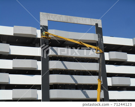 SELANGOR, MALAYSIA -FEBRUARY 16, 2017: Construction workers using mobile crane bucket while working at high level in the construction site. The bucket movement control by the workers himself.  71244123