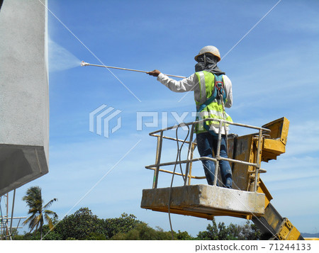 SELANGOR, MALAYSIA -FEBRUARY 16, 2017: Construction workers using mobile crane bucket while working at high level in the construction site. The bucket movement control by the workers himself.  71244133