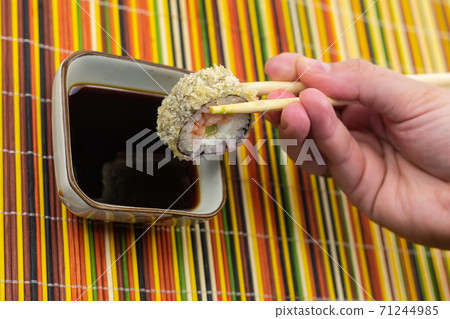 sushi roll with fish tuna kept in bamboo sticks over soy sauce close up 71244985
