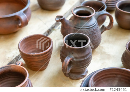 traditional european medieval tableware clay cup and plate stands on a wooden table traditional european medieval tableware clay cup and plate stands on a wooden table 71245461