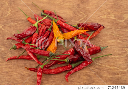 fragrant hot chili peppers red dried sprinkled on a wooden surface fragrant hot chili peppers red dried sprinkled on a wooden surface 71245489