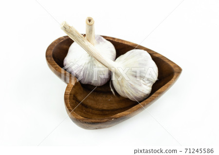 two mature heads of white garlic stands on a wooden plate and white background two mature heads of white garlic stands on a wooden plate and white background 71245586