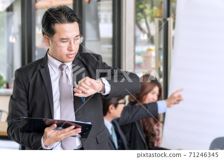 Business man checking time. Middle business people holding job broad and pen looking at wrist watch 71246345