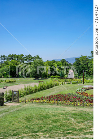 Osaka Hattori Ryokuchi, a view of the park with a blue sky overlooking the mountains of Rokko, facing the West Central Square from the circular flower bed Osaka Hattori Ryokuchi, a view of the park with a blue sky overlooking the mountains of Rokko, facing the West Central Square from the circular flower bed 71247127