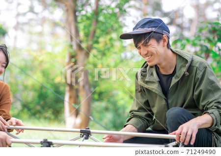 Asian men and women preparing camping equipment at the campsite (table) Asian men and women preparing camping equipment at the campsite (table) 71249490