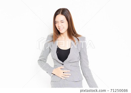 Business woman who puts her hand on her stomach Business woman who puts her hand on her stomach 71250086