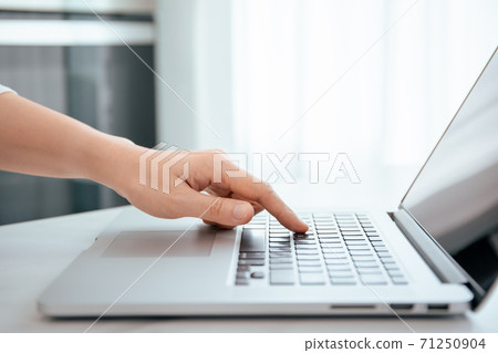 Unrecognizable woman pressing on the laptop computer keyboard by using her forefinger. Internet and online payment security concept with copyspace. 71250904
