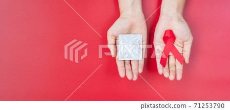 December World Aids Day Awareness month, Red Ribbon and condom on wood background for supporting people living and illness. Healthcare and safe sex concept 71253790