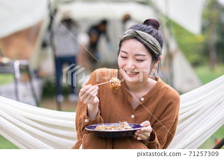 Woman eating takoyaki at camp 71257309