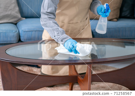 Stay-at-home husband cleaning with alcohol spray 71258567