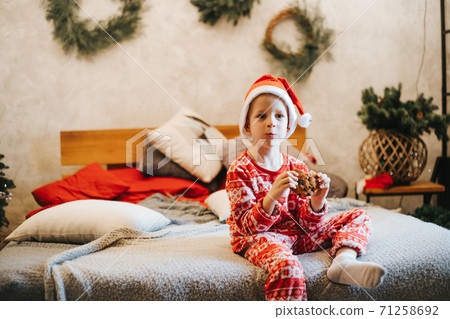 Cute boy eating delicious cookie at home Cute boy eating delicious cookie at home 71258692