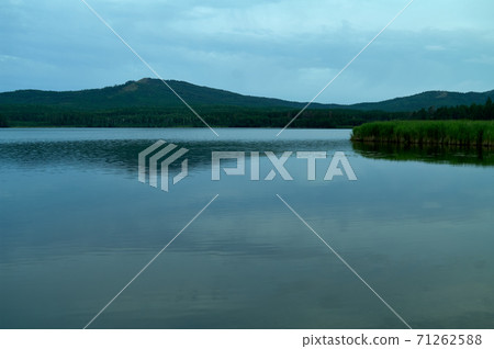 View to lake with mountain range on another shore View to lake with mountain range on another shore 71262588