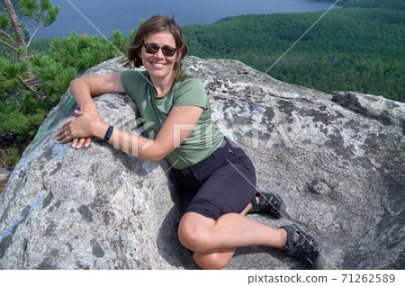 Woman sitting on the top of rock Woman sitting on the top of rock 71262589