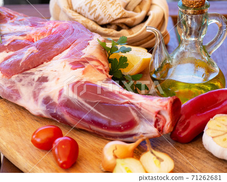 Fresh and raw meat. Leg of lamb on wood background Fresh and raw meat. Leg of lamb on wood background 71262681