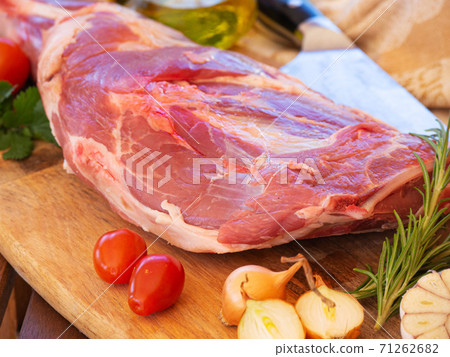 Fresh and raw meat. Leg of lamb on wood background 71262682