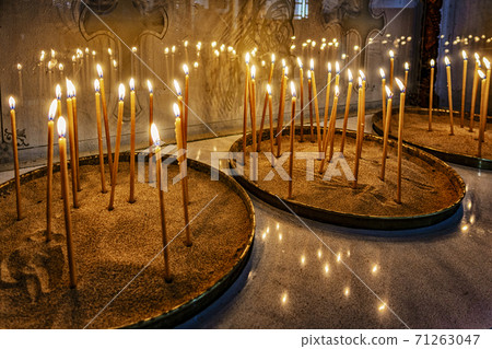 Prayer candles lit in monastery 71263047