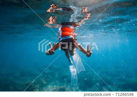 Freediver woman with Christmas cap posing underwater in blue sea. Christmas holidays Freediver woman with Christmas cap posing underwater in blue sea. Christmas holidays 71266586