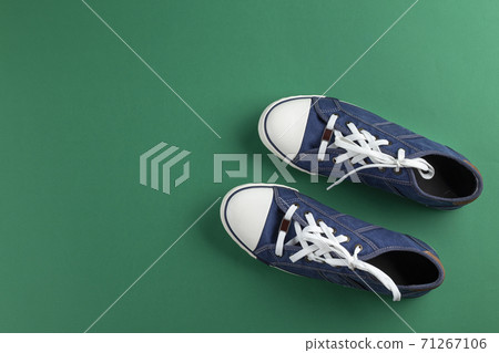 New blue gumshoes on green background 71267106
