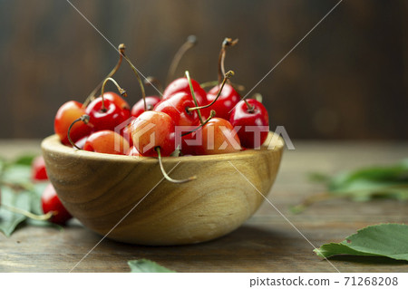 Fresh cherries with leaves in a wooden bowl 71268208