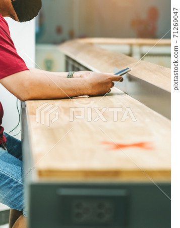 Man using mobile phones for work with blurred image of alternative seating mark for social distance rules distance for one seat from other people to protect from Corona Virus(COVID-19) in foreground 71269047