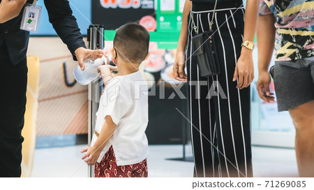 Hand of customer waits for a drop of alcohol gel from female security guard to prevent the spread of germs and bacteria and avoid infections Corona virus (Covid-19) before entering the mall. Hand of customer waits for a drop of alcohol gel from female security guard to prevent the spread of germs and bacteria and avoid infections Corona virus (Covid-19) before entering the mall. 71269085