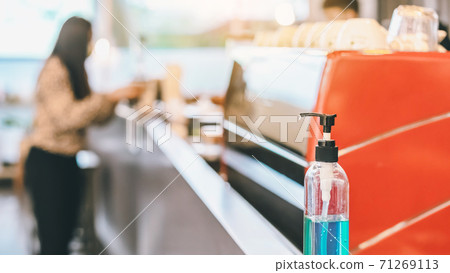 Blue alcohol gel bottle for hands cleaning to prevent the spreading of the Corona virus (Covid-19), Place the entrance service for customers in the cafe. Healthcare concept. New normal lifestyle. Blue alcohol gel bottle for hands cleaning to prevent the spreading of the Corona virus (Covid-19), Place the entrance service for customers in the cafe. Healthcare concept. New normal lifestyle. 71269113