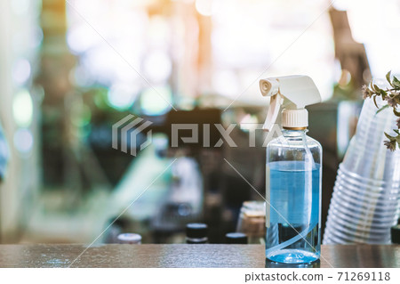 Blue alcohol sprayer bottle for hands cleaning to prevent the spreading of the Corona virus (Covid-19),Place the entrance service for customers in the cafe. Healthcare concept. New normal lifestyle. Blue alcohol sprayer bottle for hands cleaning to prevent the spreading of the Corona virus (Covid-19),Place the entrance service for customers in the cafe. Healthcare concept. New normal lifestyle. 71269118