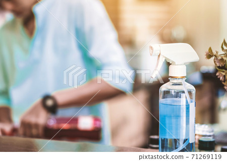 Blue alcohol sprayer bottle for hands cleaning to prevent the spreading of the Corona virus (Covid-19),Place the entrance service for customers in the cafe. Healthcare concept. New normal lifestyle. Blue alcohol sprayer bottle for hands cleaning to prevent the spreading of the Corona virus (Covid-19),Place the entrance service for customers in the cafe. Healthcare concept. New normal lifestyle. 71269119