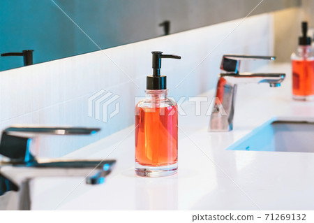 Orange sanitary liquid soap or antivirus soap sanitizer for hand washing to prevent the spread of germs and bacteria and avoid infections Corona virus (Covid-19). New normal lifestyle. Orange sanitary liquid soap or antivirus soap sanitizer for hand washing to prevent the spread of germs and bacteria and avoid infections Corona virus (Covid-19). New normal lifestyle. 71269132