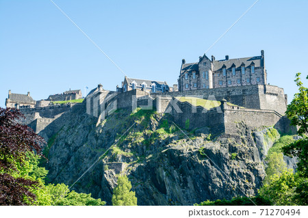 A historic Edinburgh castle on a stone mountain under a clear sky A historic Edinburgh castle on a stone mountain under a clear sky 71270494