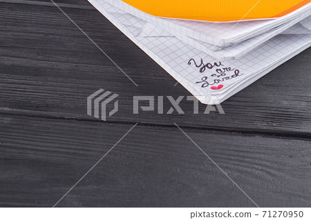 Close-up copybook on dark wood. 71270950