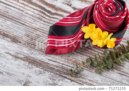Rolled red tie with yellow flowers. Rolled red tie with yellow flowers. 71271235