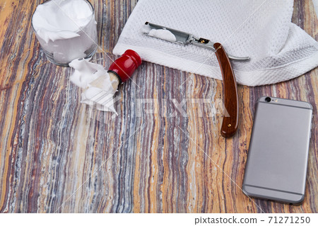 Shaving stuff and smartphone on rustic wooden table. 71271250