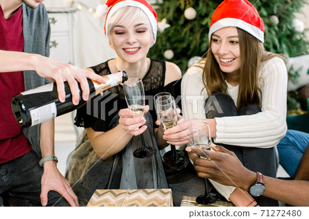 Group of young people toasting with glasses in Christmas eve Group of young people toasting with glasses in Christmas eve 71272480