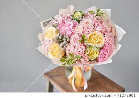 Beautiful spring bouquet on wooden table.. Arrangement with various flowers. The concept of a flower shop. A set of photos for a site or catalogue. Work florist. 71272901