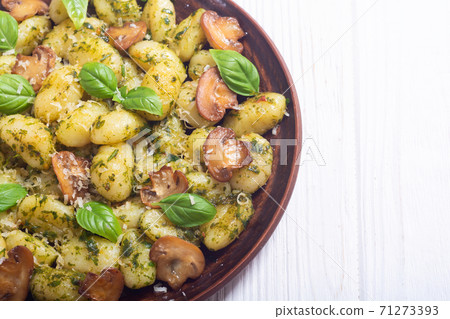 Homemade potatoes gnocchi with basil , cheese and mushrooms Homemade potatoes gnocchi with basil , cheese and mushrooms 71273393