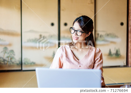 A woman who lives in the country and works using a computer A woman who lives in the country and works using a computer 71276694