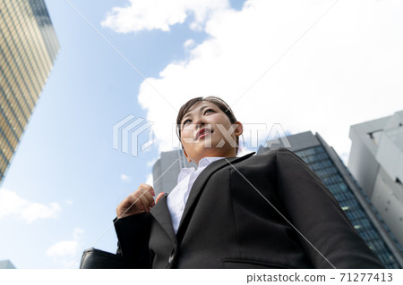 年輕的女僱員,在商業區散步/做工作的婦女 年輕的女僱員,在商業區散步/做工作的婦女 71277413