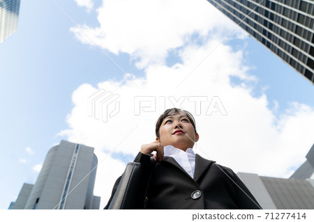 Young female employees walking in the business district / women doing job hunting Young female employees walking in the business district / women doing job hunting 71277414