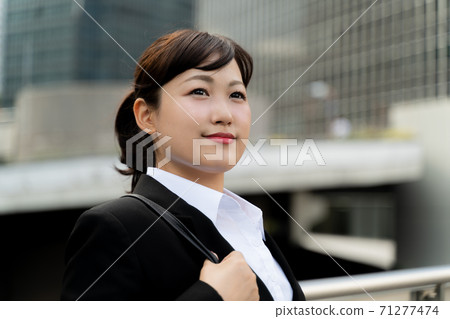 年輕的女僱員,在商業區散步/做工作的婦女 年輕的女僱員,在商業區散步/做工作的婦女 71277474