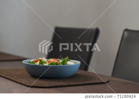 Salad with avocado, cherry tomatoes, romaine and mozzarella in blue bowl on walnut table with copy space Salad with avocado, cherry tomatoes, romaine and mozzarella in blue bowl on walnut table with copy space 71280924