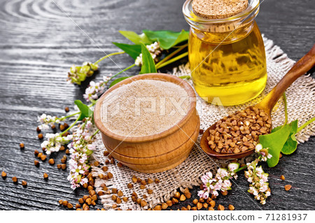 Flour buckwheat brown in bowl with oil on dark wooden board 71281937