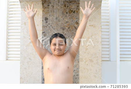 Happy obese boy taking shower before swimming, 71285393